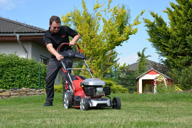 Man mowing lawn with push mower